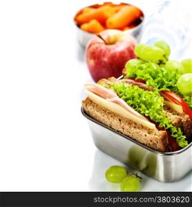 Lunch box with sandwich, fruits and water on white background
