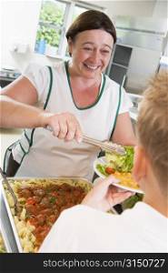 Lunch lady serving salad to student