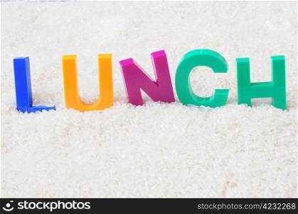 Lunch - word made of colorful plastic letters in the rice