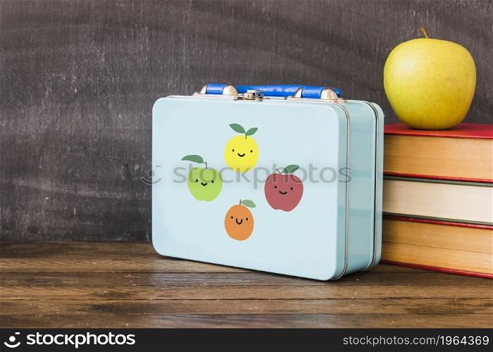 lunchbox near stack books apple. High resolution photo. lunchbox near stack books apple. High quality photo