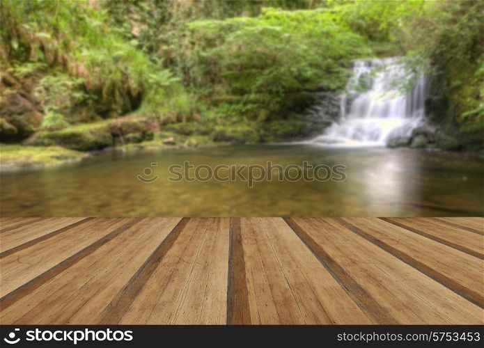 Lush green forest landscape and waterfall with wooden planks floor
