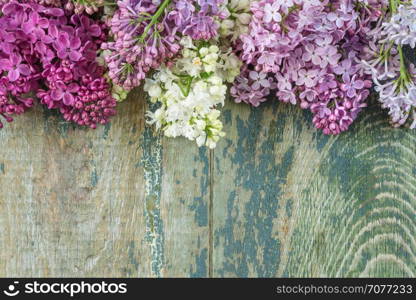 Lush multicolored bunches of lilac flowers on an old wooden background