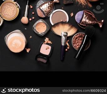 luxery Set of bronze powder with makeup brushes on black background