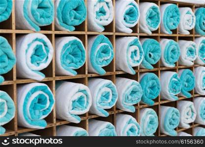 luxury and hygiene concept - close up of shelf with rolled bath towels at hotel spa. close up of shelf with rolled bath towels