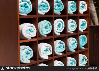 luxury and hygiene concept - close up of shelf with rolled bath towels at hotel spa. close up of shelf with rolled bath towels