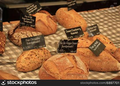 Luxury artisanal bread at a market (text on tags: product and price information in Dutch)