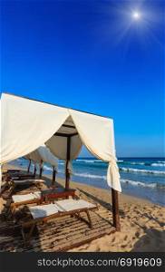 Luxury beach tents canopies on sunshiny morning paradise white sandy beach Maldives of Salento (Pescoluse, Salento, Puglia, south Italy). The most beautiful sea sandy beach of Apulia.