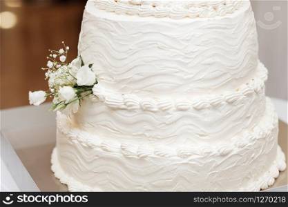 luxury Beautiful wedding white cake with white roses at wedding reception. wedding day.. luxury Beautiful wedding white cake with white roses at wedding reception. wedding day