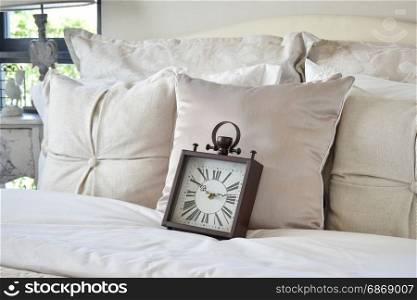 luxury bedroom interior with classic style alarm clock on bed