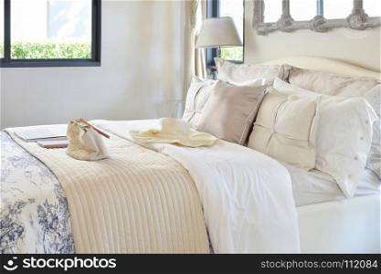 luxury bedroom interior with decorative set with vintage bag,hat,books on bed and classic style table lamp