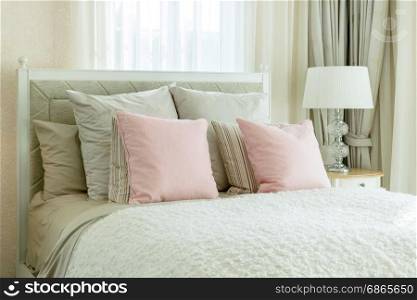 luxury bedroom interior with pink pillows and reading lamp on bedside table