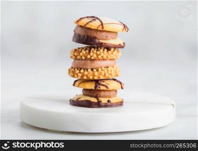 Luxury belgian chocolate and biscuit cookies selection on marble coasters and kitchen table background.