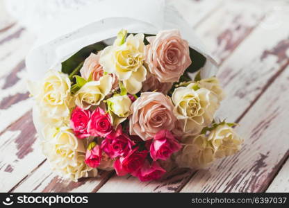 Luxury bouquet of roses lying on a wooden board. Bouquet of roses