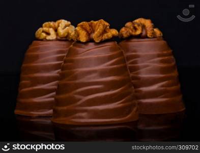Luxury elegant milk chocolate candy with walnut on black background