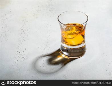 Luxury glass of finest whiskey with ice cubes on light background.Top view.