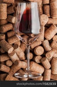 Luxury glass of red wine on top of various wine corks. Macro
