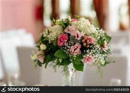 Luxury holiday or wedding table, richly decorated with beautiful floral bouquets. Floral compositions with fresh roses. Luxury holiday or wedding table, richly decorated with beautiful floral bouquets. Floral compositions with fresh roses.