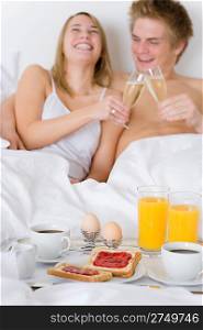 Luxury hotel honeymoon breakfast - couple in white bed together