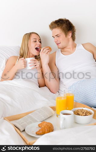 Luxury hotel honeymoon breakfast - couple in white bed together