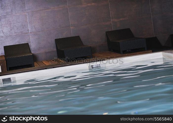 luxury indoor swimming pool with wooden chair and bed