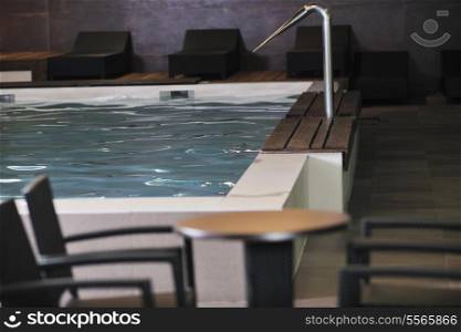 luxury indoor swimming pool with wooden chair and bed