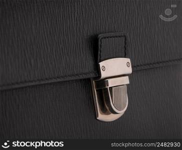 luxury lock clasp on black leather bag, close-up. the clasp on the black bag