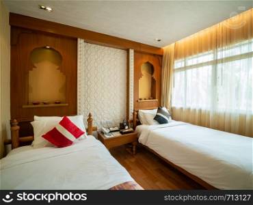 Luxury room with bed in warm light, India style, room of hotel resort in Thailand.