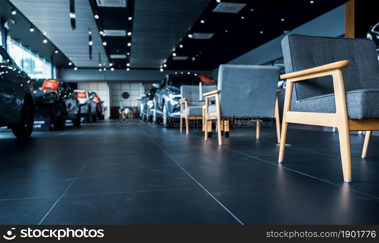 Luxury showroom interior. Car dealership office. New car parked in modern showroom and chairs for customer service. Car for sale and rent business concept. Automobile leasing and insurance background.
