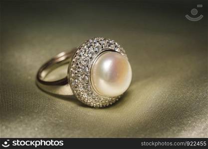 Luxury silver ring decorated with freshwater pearl of white color and diamonds.