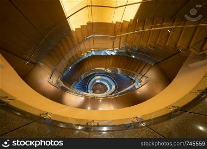 Luxury spiral staircase in lobby hotel with marble floor. Lighting architecture interior design decoration