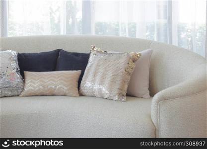 Luxury style pillows on round shape sofa with sheer curtain in background