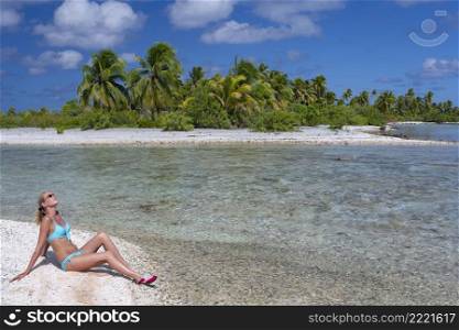 Luxury vacation - Sunbathing at a tropical lagoon on a small island in the Mahini Islands of French Polynesia in the South Pacific.