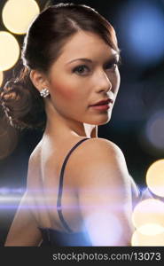 luxury, vip, nightlife, party concept - beautiful woman in evening dress wearing diamond earrings