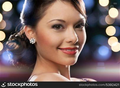 luxury, vip, nightlife, party concept - beautiful woman in evening dress wearing diamond earrings