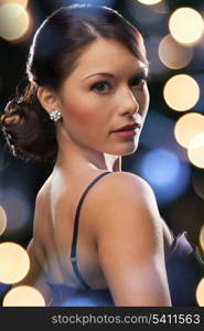 luxury, vip, nightlife, party concept - beautiful woman in evening dress wearing diamond earrings