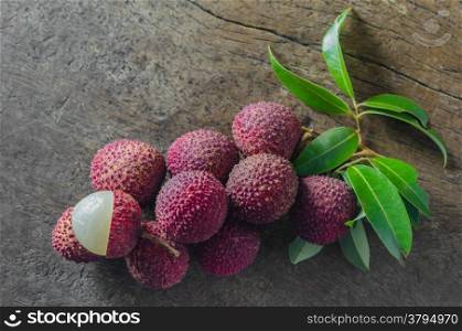 Lychee fruit. Lychee with leaves on a wooden table