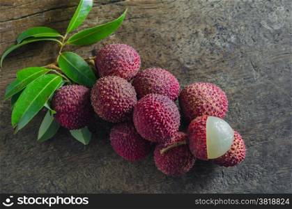 Lychee fruit. Lychee with leaves on a wooden table