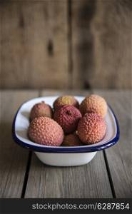 Lychees in rustic setting with wooden background