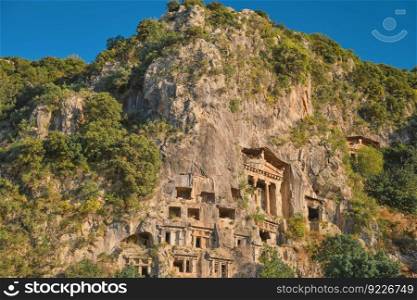 Lycian rock tombs in the city of Fethiye on the Aegean coast of Turkey, Lycian tombs at sunset in spring, the rock-cut tombs of Amyntas rise above the city, travel and vacation time