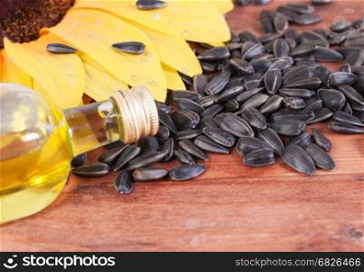 Lying on the boards, the bottle of oil and sunflower seeds. Focus on the bottle.. The bottle of oil and sunflower seeds. Close-up.