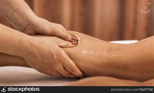 Lymphatic drainage massage. Hands of a masseuse massaging leg of a female client. Lymphatic Drainage Massage