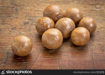macadamia nuts in shells on a rustic grunge wood