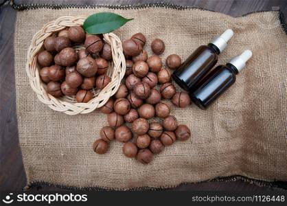 Macadamia oil in bottles and macadamia nuts, flat lay, vintage rustic style . Bio, organic , nature cosmetics concept