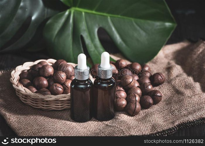 Macadamia oil in bottles and macadamia nuts , vintage rustic style . Bio, organic , nature cosmetics concept