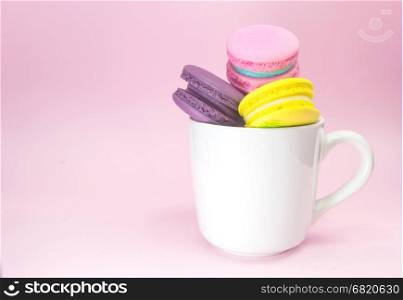 macaron in cup on pink background