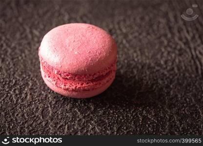 Macaron - meringue confection on the dark background