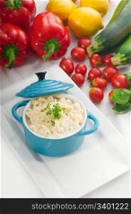 macaroni and cheese,kids favourite dish , on a blue little childish clay pot with vegetables on background,MORE DELICIOUS FOOD ON PORTFOLIO