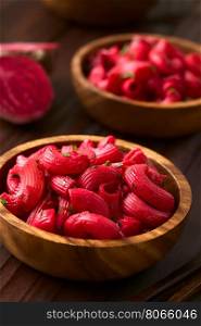 Macaroni pasta with beetroot and parsley in wooden bowls, photographed with natural light (Selective Focus, Focus in the middle of the first dish)