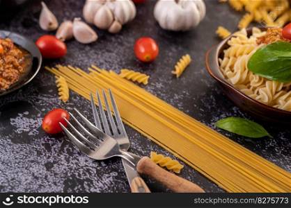 Macaroni sauteed with tomatoes and basil on a gray plate.