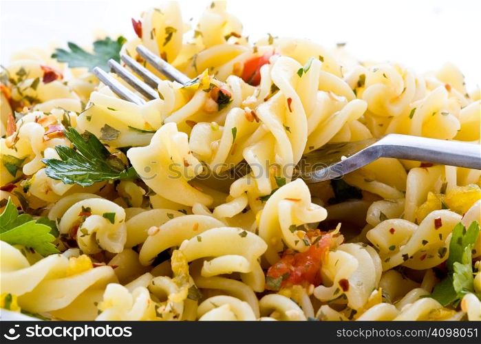 Macaroni with greens on a plate with a fork